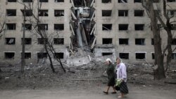 Women walk past a hostel destroyed during a missile attack in the town of Selydove, in Ukraine's eastern Donetsk region, on April 14.