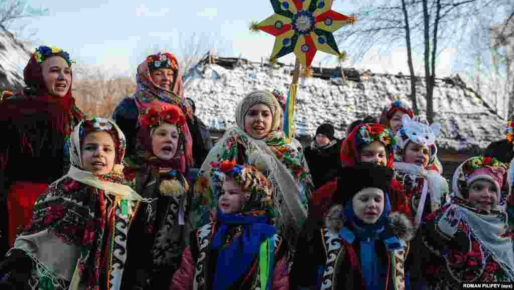 Украинские дети в традиционных одеждах поют колядки в селе Пирогово под Киевом