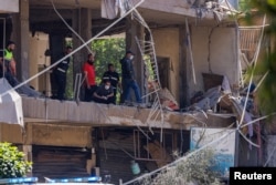 Police officers and emergency personnel work at the site of an Israeli strike on the southern suburbs of Beirut on June 14.