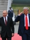 US President Donald Trump salutes as he walks with Russian President Vladimir Putin on the tarmac after they arrived at Joint Base Elmendorf-Richardson in Anchorage, Alaska, on August 15, 2025.