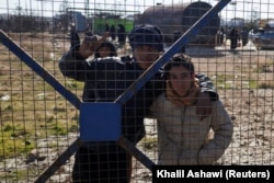 Dječaci kod ograde kampa Al-Hol nakon nakon što je sirijska vlada preuzela kontrolu nad njim nakon povlačenja Sirijskih demokratskih snaga (SDF), 21. januar 2026.