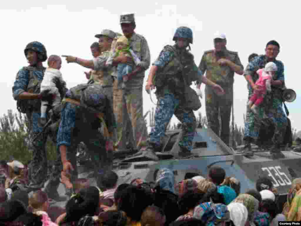 Uzbek border guards try to assist fleeing ethnic Uzbeks at the Kyrgyz border. Photo courtesy of EurasiaNet