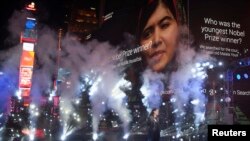 U.S. singer Idina Menzel performs as an image of Malala Yousafzai is projected on a screen in Times Square on New Year's Eve in New York.