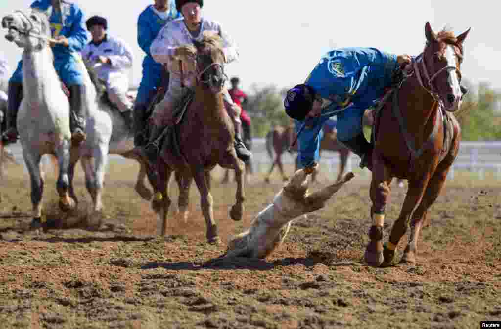 A Kazakh team member drags the goat during the match against Russia.