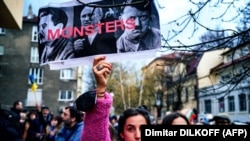 A woman holds up a poster with an image of Josef Stalin, Vladimir Putin, and Adolf Hitler with the inscription "Monsters" during a demonstration to support Ukraine in front of Russia's cultural center in downtown Sofia in April.