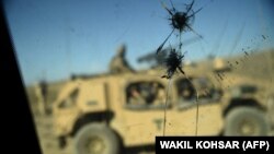 Автомобиль с военнослужащими США виден из вооруженного транспортного средства у контрольно-пропускного пункта в афганской провинции Нангархар. 7 июля 2018 года.