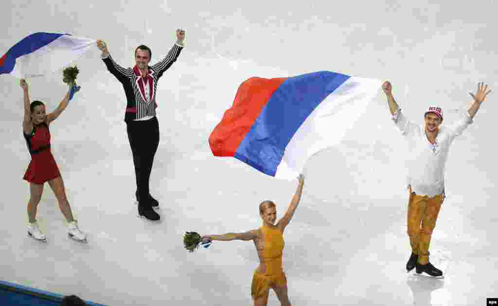 Gold medalists Tatyana Volosozhar (2nd right) and Maksim Trankov (right) of Russia and silver medalists Ksenia Stolbova (left) and Fedor Klimov (2nd left) of Russia celebrate after the pairs free skating of the figure-skating event at the Iceberg Palace.