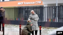 Родственники убитого мальчика на фоне школы