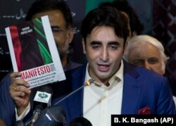 Bilawal Bhutto-Zardari, leader of Pakistan Peoples party shows a copy of his party's manifesto for the forthcoming election in Islamabad on June 28.