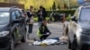EDITORS NOTE: Graphic content / TOPSHOT - Police experts examine a body of a person shot by a gunman outside a supermarket in Kyiv on April 18, 2026.