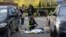 EDITORS NOTE: Graphic content / TOPSHOT - Police experts examine a body of a person shot by a gunman outside a supermarket in Kyiv on April 18, 2026.