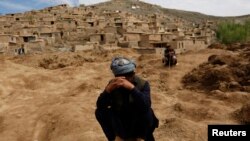 Afghan survivors mourn for their relatives at the site of a landslide at the Argo district in Badakhshan Province.