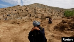 Survivors mourn for their relatives at the site of a landslide in Badakhshan province.