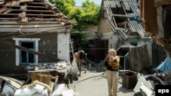 A local woman stands next to her shell-damaged house in Ukraine's Donbas region. (file photo)