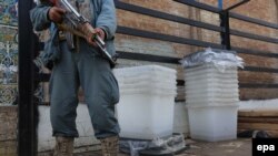 An Afghan police officer stands guard during the transportation of ballot boxes to polling stations ahead of April's first round.