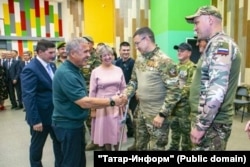 Военнослужащий Артур Барабанов жмет руку главе Татарстана Рустаму Минниханову