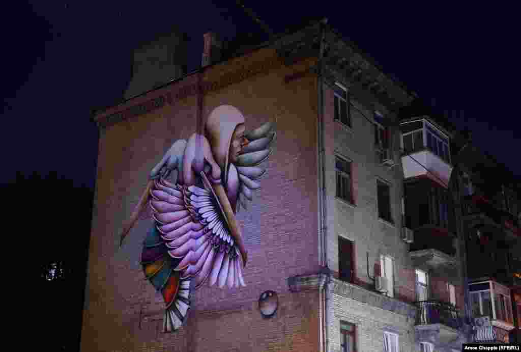 This mural of phoenixes rising with a human figure is by Ana Marietta. The Puerto Rican artist said of her time in Kyiv: "I was able to witness beauty in so many ways. The architecture, the beautiful people, their kindness.... I wanted to skip the language barrier...sending them a message of solidarity, of love." 