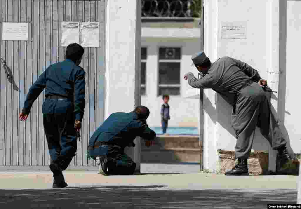 Owgan polisiýasy Kabulda, 25-nji awgustda şaýy metjidine guralan hüjümden we pitneçiler bilen hökümet güýçleriniň çaknyşygyndan soň, janyndan geçeniň özüni partladan ýerindäki çagany halas etjek bolýarlar. &nbsp;(Reuters/Omar Sobhani)