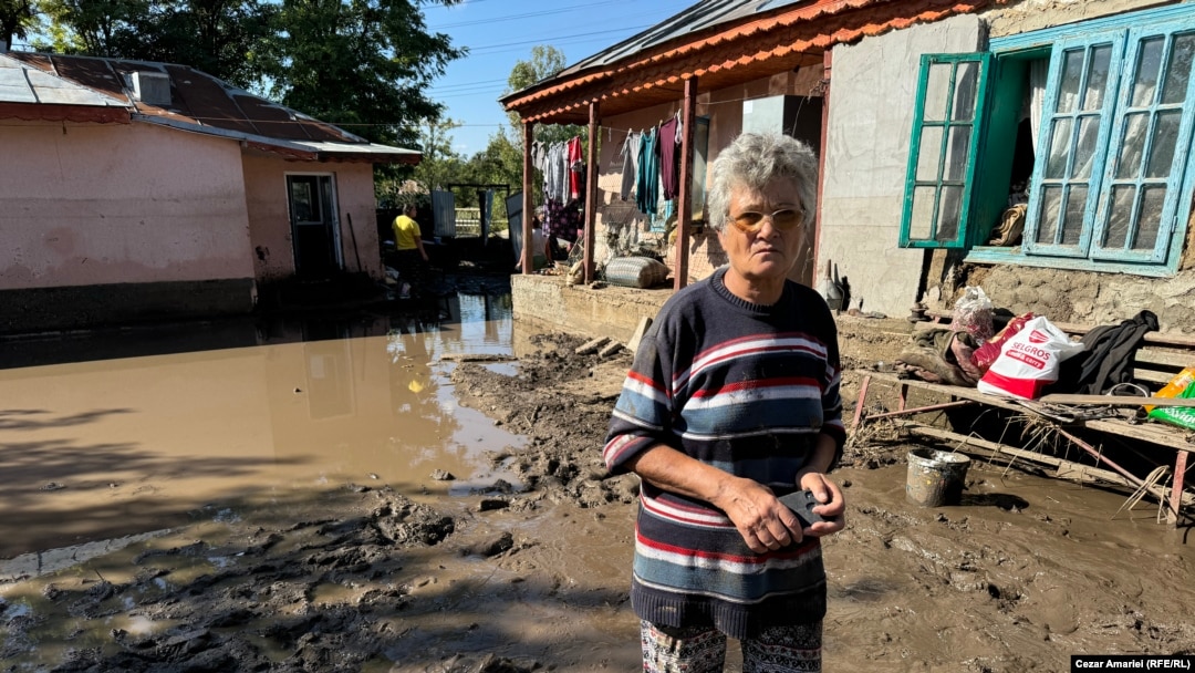 Stefana Bodea în curtea casei inundate din Slobozia Conachi, la două zile după ce viitura a obligat-o să urce în podul casei, cu familia, pentru a supraviețui