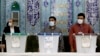 Iranian election officials wait for voters to arrive during the presidential election at a polling station in Tehran on June 18.