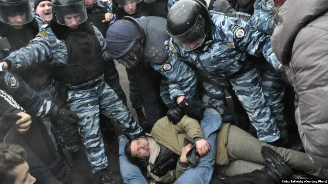 Cутичка активістів і «Беркута» в Гостиному дворі, Київ (на землі – депутат Володимир Бригинець), 18 лютого 2013 року