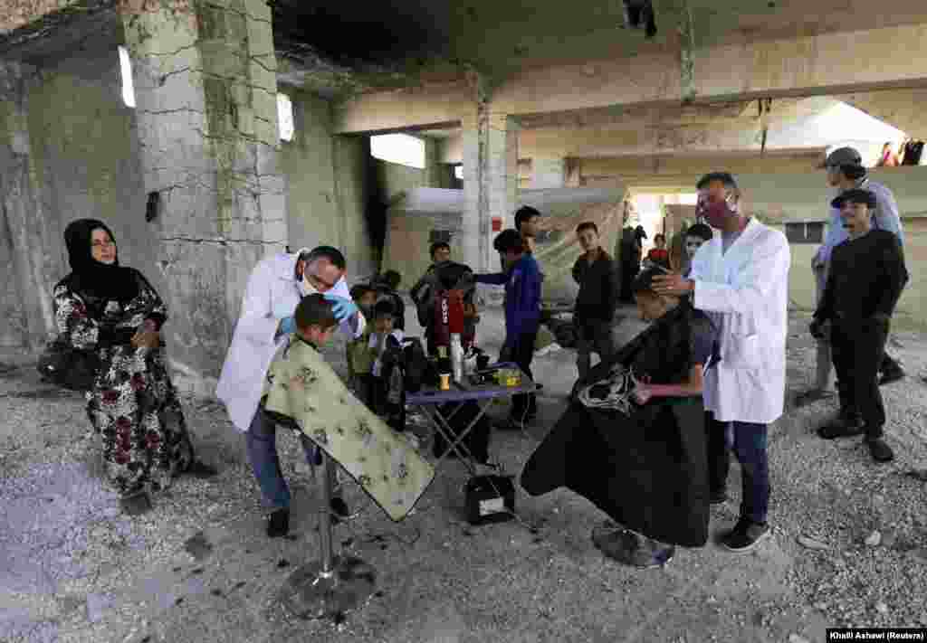 Volunteer hairdressers from the International Association for Relief and Development cut the hair of internally displaced children ahead of the Muslim holiday of Eid al-Fitr at a camp in Idlib, Syria. (Reuters/Khalil Ashawi)