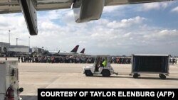 برخی مسافران در حال تخلیه از باند فرودگاه