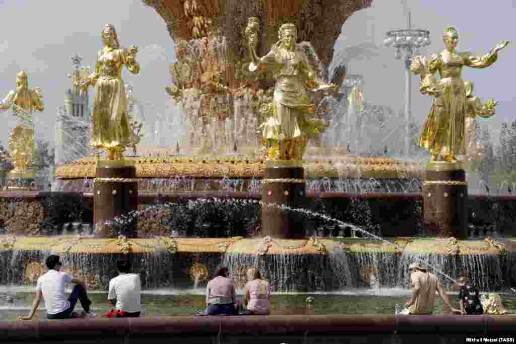 Muscovites enjoy warm weather near a fountain in the Russian capital on June 11. (TASS/Mikhail Metzel)