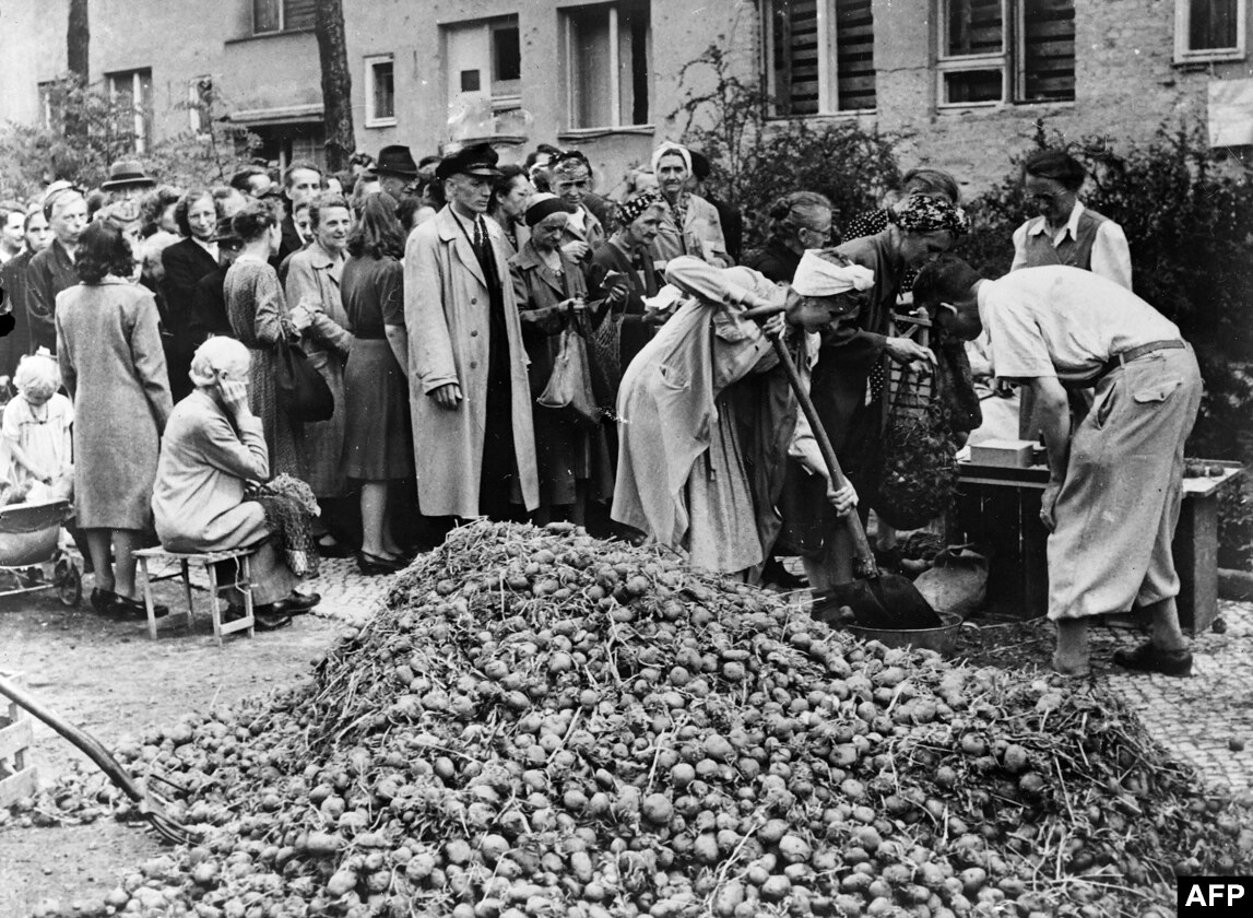 向柏林人分發馬鈴薯。蘇聯施粥所分發了大量食物，但戰後的食物短缺使許多柏林人瀕臨飢餓。  