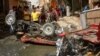 Residents of Diwaniya, Iraq, inspect damaged vehicles at the site of a bomb attack that targeted Shi'ite Muslims earlier this month. 