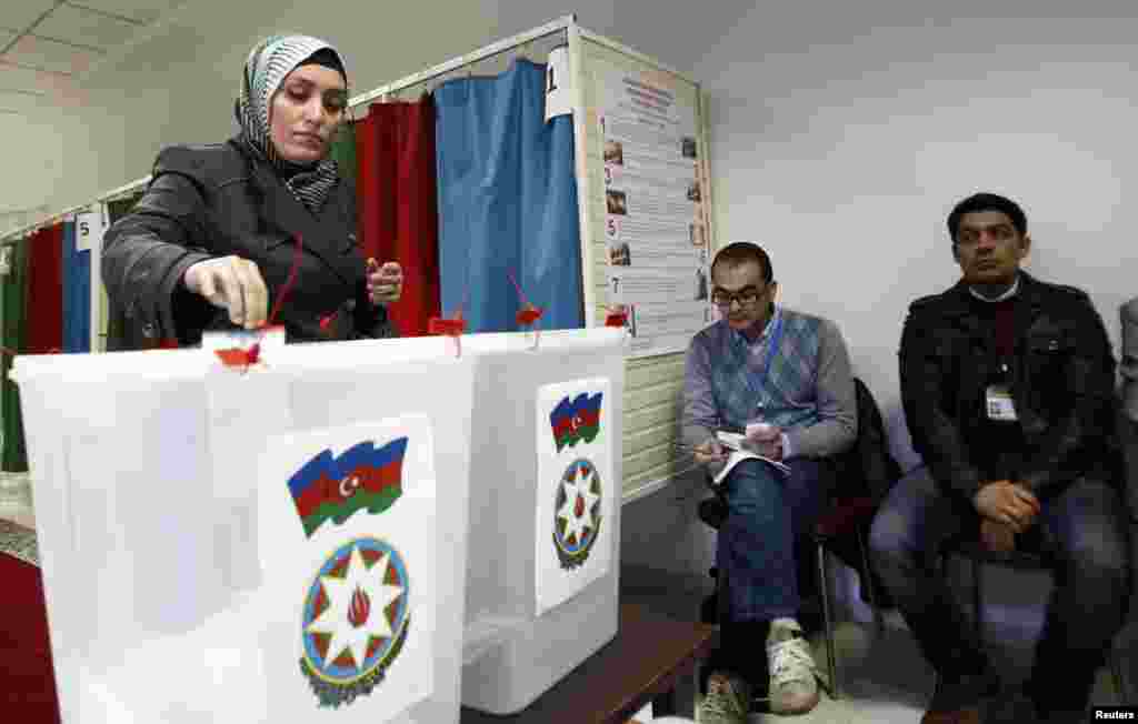 A woman casts her vote during the presidential election at a polling station in Baku.