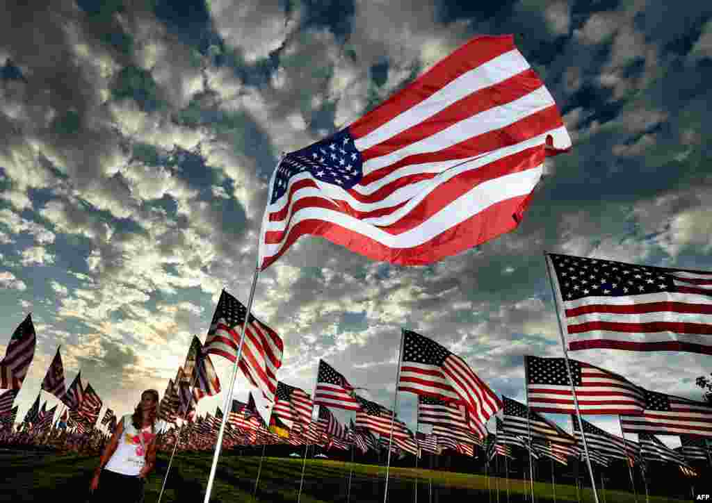 A woman walks among U.S. national flags erected by students and staff from Pepperdine University to honor the victims of the September 11, 2001, attacks in New York, at their campus in Malibu, California. (AFP/Mark Ralston)