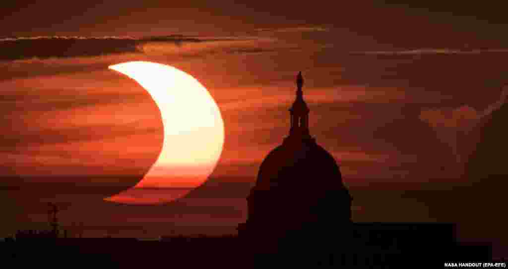 Солнце восходит слева от здания Капитолия в Вашингтоне, США