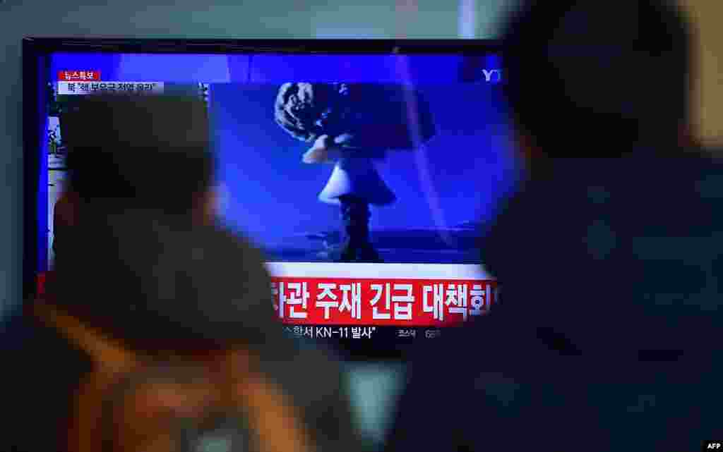 На одном из железнодорожных вокзалов Сеула люди смотрят по телевизору выпуск новостей, в котором в этот момент сообщают об испытаниях в КНДР
