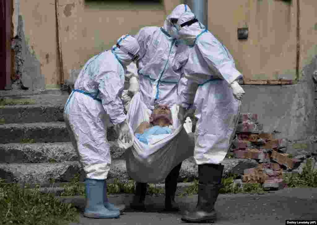 Medical workers carry a patient at an infectious diseases hospital where patients with the coronavirus are treated in St. Petersburg, Russia. (AP/Dmitri Lovetsky)