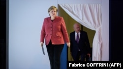 Angela Merkel (solda) və Dünya İqtisadi Forumunun rəhbəri Klaus Schwab 