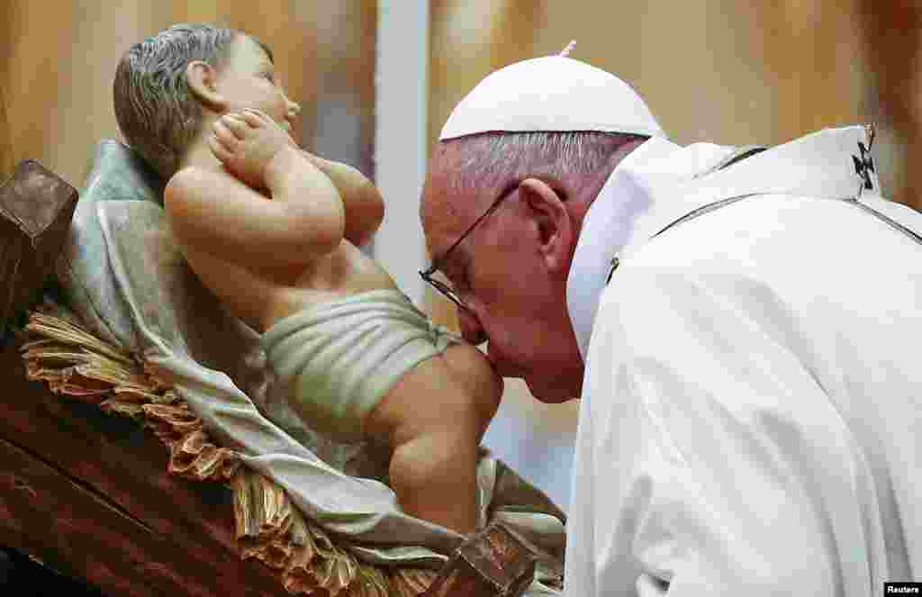 Папа Римский Франциск целует статую маленького Иисуса во время рождественской службы в Соборе Святого Петра в Ватикане. 24 декабря 2015 года.&nbsp;