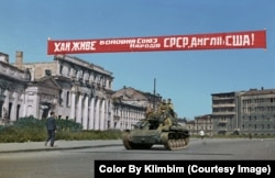 A tank in Kharkiv, Ukraine, in 1943 rumbling under a banner reading "Long live the military union of the peoples of the USSR, England and USA!"