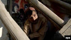 Një banor qëndron në dhomën e dëmtuar rëndë nga tërmeti në Afganistan