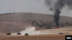 Turkish tanks and members of the Free Syrian Army pass the Syrian border as part of an operation against Islamic State in Syria on August 24.