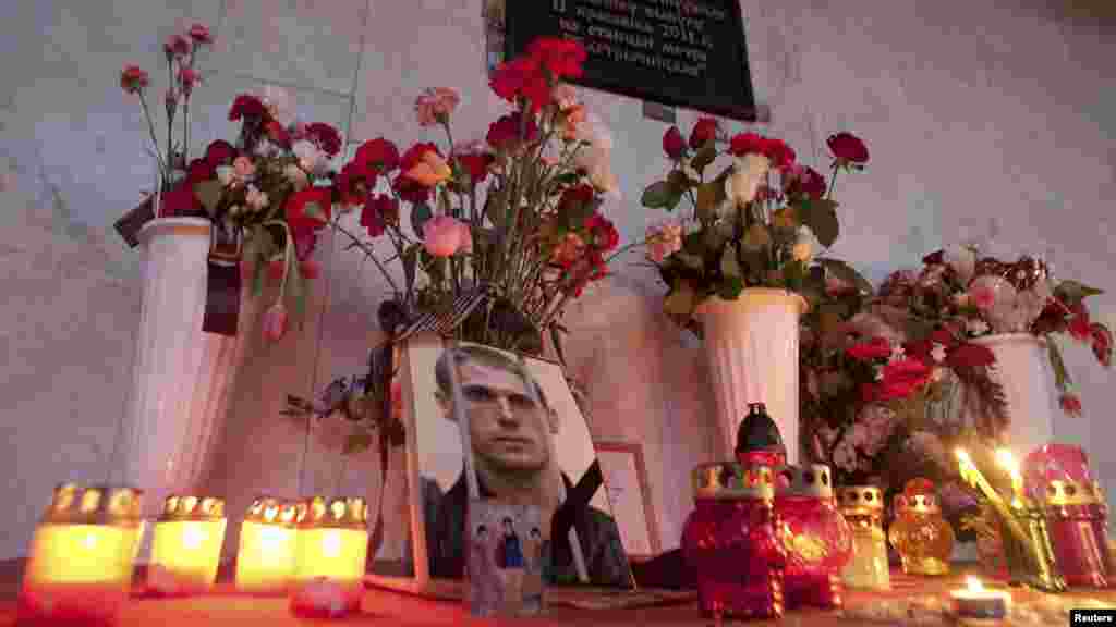 A portrait of Uladzislau Kavalyou is seen among candles and flowers at the entrance of a metro station in central Minsk on March 17. Belarus executed the two men convicted for the fatal 2011 metro bombing, despite protests from European human rights groups and calls for a retrial. (Reuters/Aleksander Vasukovich)