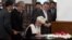 Afghan President Ashraf Ghani (C) signs a peace deal with Afghan warlord Gulbuddin Hekmatyar at the Presidential Palace in Kabul on September 29.