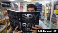 A customer in an Islamabad bookstore looks at Spy Chronicles, a new tell-all tome by former Indian and Pakistani intelligence chiefs that has caused a storm in both countries.