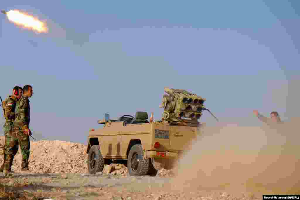 Mahmood's photos from the front lines in Bashiqa show Peshmerga fighters launching rockets toward territory under militant control. 
