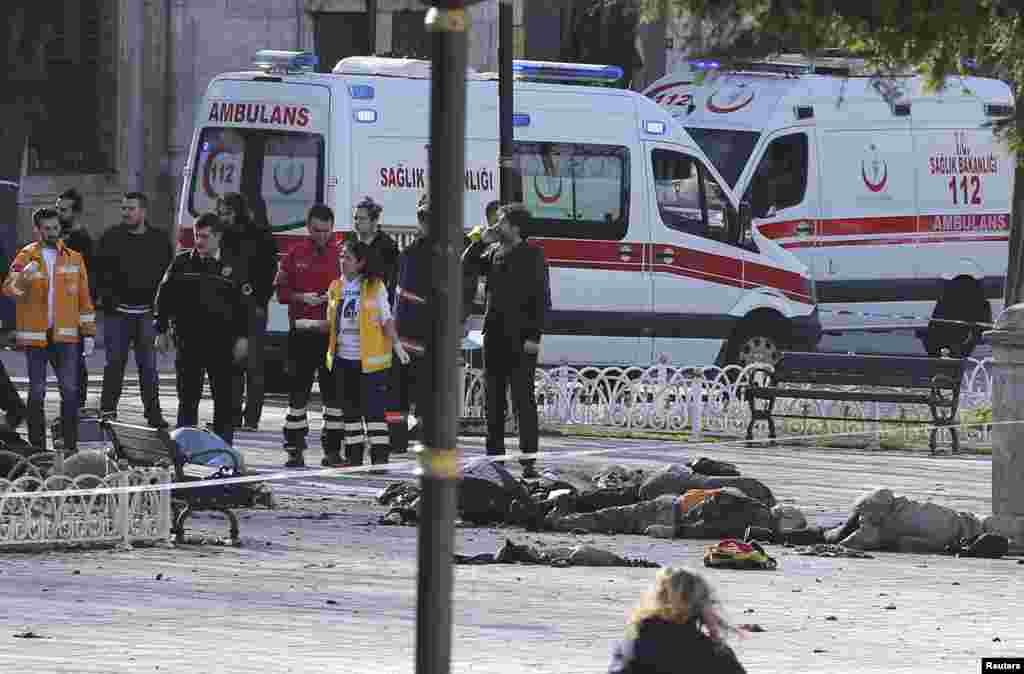 Police secure the area after the explosion, with bodies seen on the sidewalk where they fell.