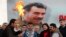 An image of militant Kurdish leader Abdullah Ocalan provides the backdrop for pro-Kurdish activists lighting a Norouz fire in Istanbul on March 17.