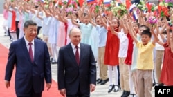 Xi, Putin și copii chinezi la ceremonia de primire a liderului rus la Beijing, pe 20 mai 2026. 