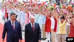 Президент Росії Володимир Путін та голова Китаю Сі Цзіньпін беруть участь у церемонії привітання у Будинку народних зборів у Пекіні, Китай, 20 травня 2026 року