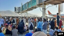 People crowd the tarmac of Kabul's airport on August 16, hoping to flee the country as the Taliban take in control of Afghanistan.