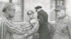 Вязень Бухэнвальду пасьля вызваленьня амэрыканцамі зьвяртаецца да ахоўніка лягеру, які жорстка зьбіваў зьняволеных. Красавік 1945 году. 